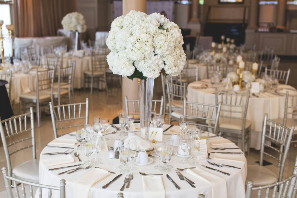 Beautifully decorated wedding reception table with elegant floral centerpiece and silverware.